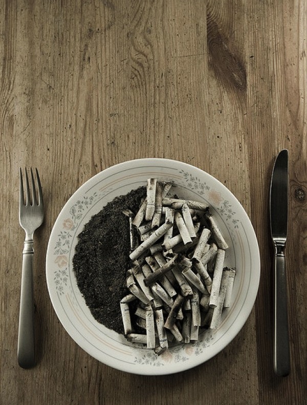 Anuncio anti-tabaco con plato lleno de ceniza y colillas